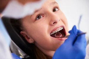 girl getting clear braces cleaned
