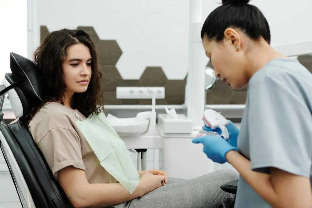 Clinician explains treatment time differences between Invisalign and lingual braces to patient.