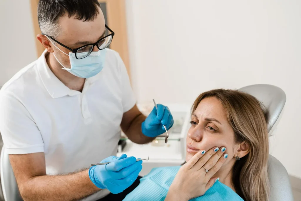 Dentist checking if teeth grinding causes tooth pain or jaw stiffness in patients.