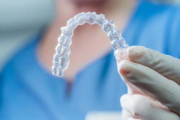 Female doctor holding a transparent dental aligner